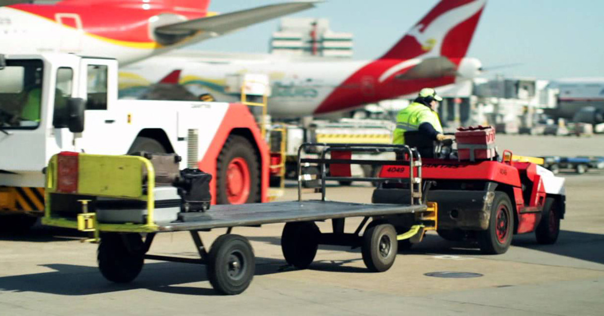 Qantas Baggage Handler Driving Trolley Around Aircraft Domestic Airport