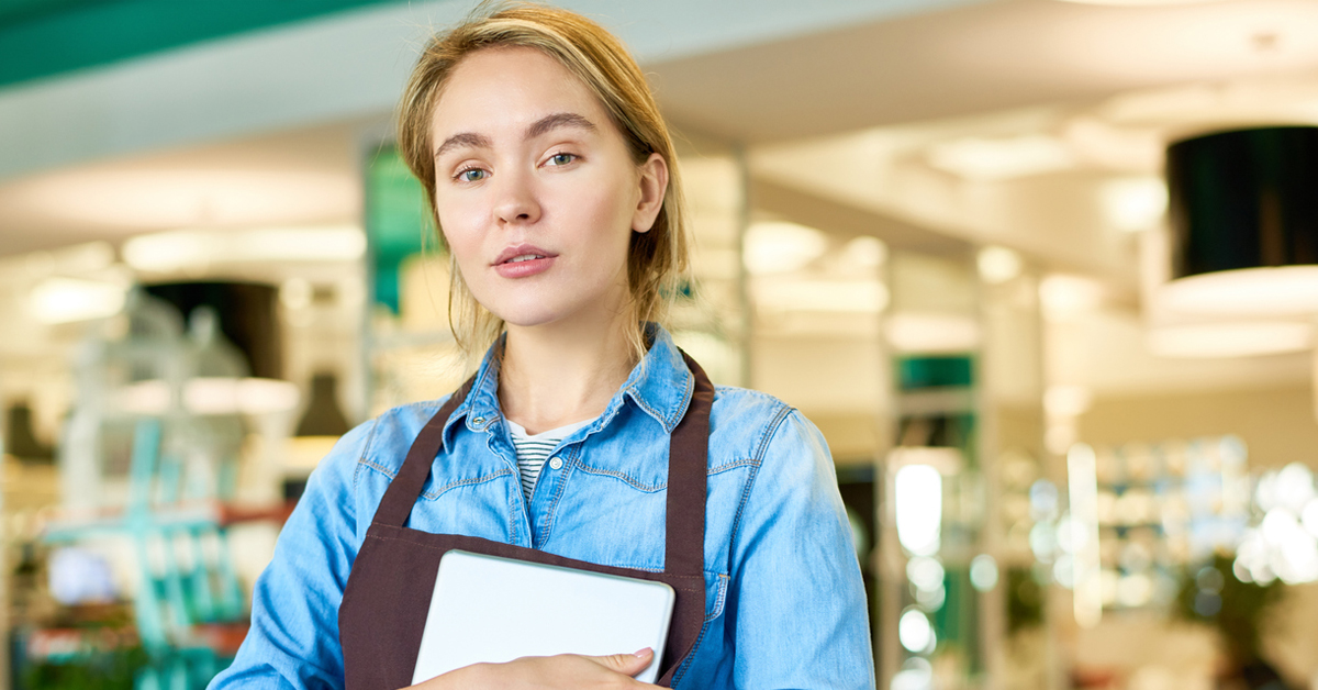 Female Retail Workers Holding Clip Board Outside Store